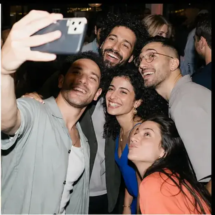 אורחים צוחקים יחד סביב שולחן באירוע